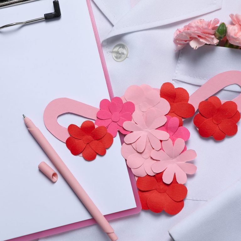 Doctors coat with flowers, clipboard, pen and uterus - Doctor Gynecologist