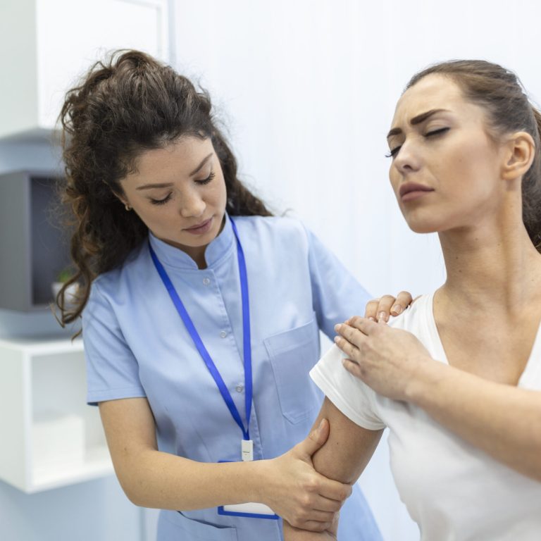Woman doctor osteopath in medical uniform fixing woman patients shoulder and back joints in manual therapy clinic during visit. Professional osteopath during work with patient concept